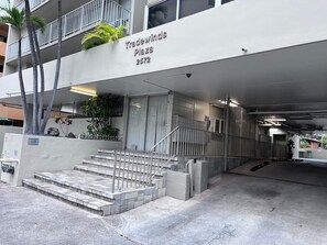 A building with a sign reading 'Tradewinds Plaza 2572' and a set of stairs leading to the entrance. - Simple Studio 1 block from Beach (Honolulu)