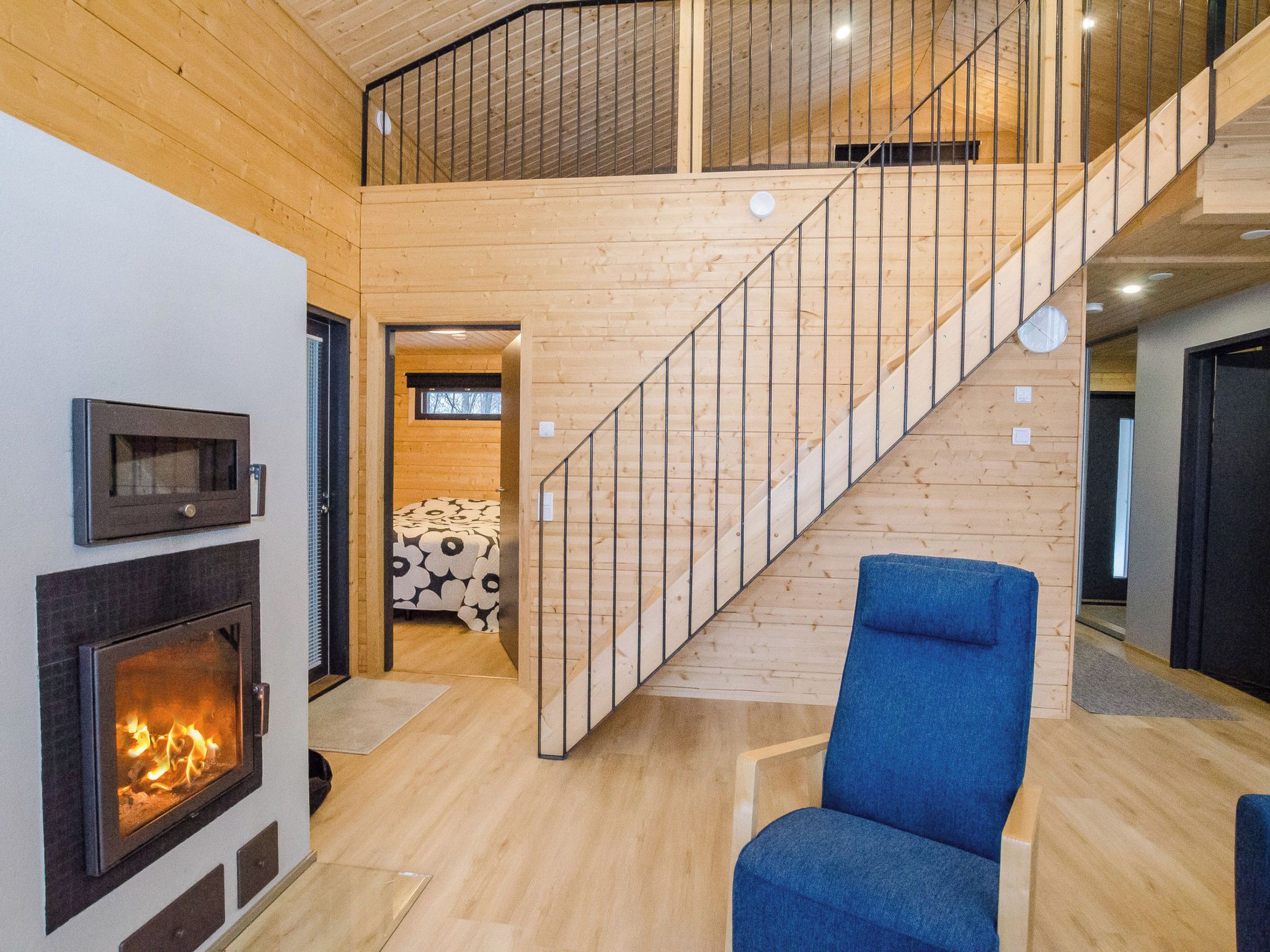 Un interior modern amb una escala de fusta, una llar de foc i una catifes amb un disseny original.