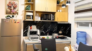 Una cocina moderna con armarios de madera, un refrigerador, un microondas y un comedor con mesa y sillas.