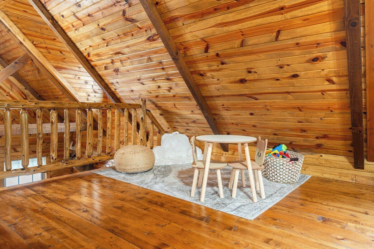 Ein Holzinterieur mit Holztisch und -stühlen, einem gewebten Pouf und einem Korb.