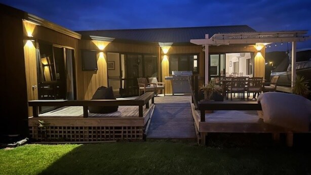 An outdoor patio area with seating, a grill, and a covered dining space.