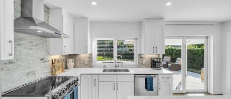 Frigorífico, placa de cocina, cafetera o tetera y mesa de comedor