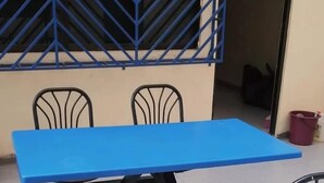 A dining area with a blue table and two chairs, one with a red seat. - CJ HOMESTAY (Batam)
