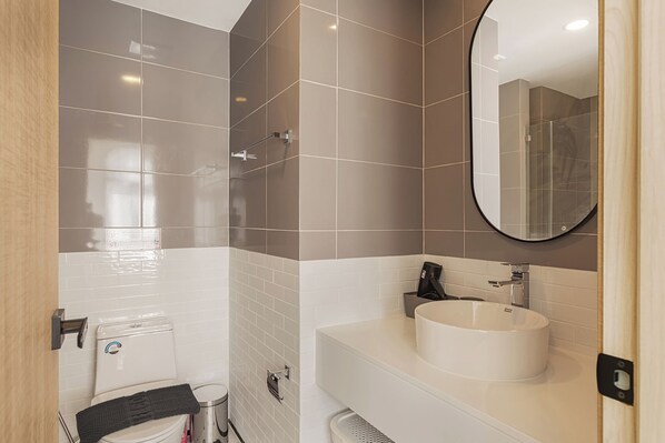 A modern bathroom with a toilet, sink, and shower.
