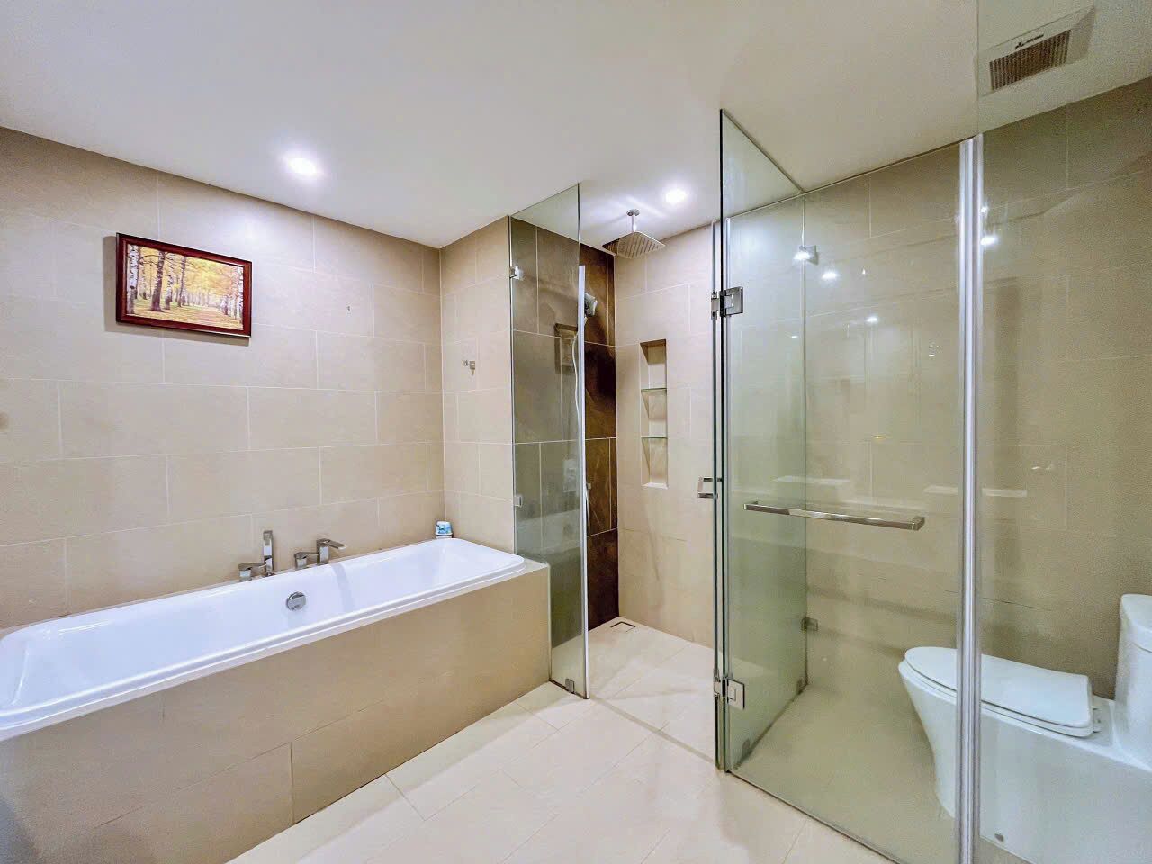 Un baño moderno con ducha envuelta en vidrio, una bañera grande y un inodoro.