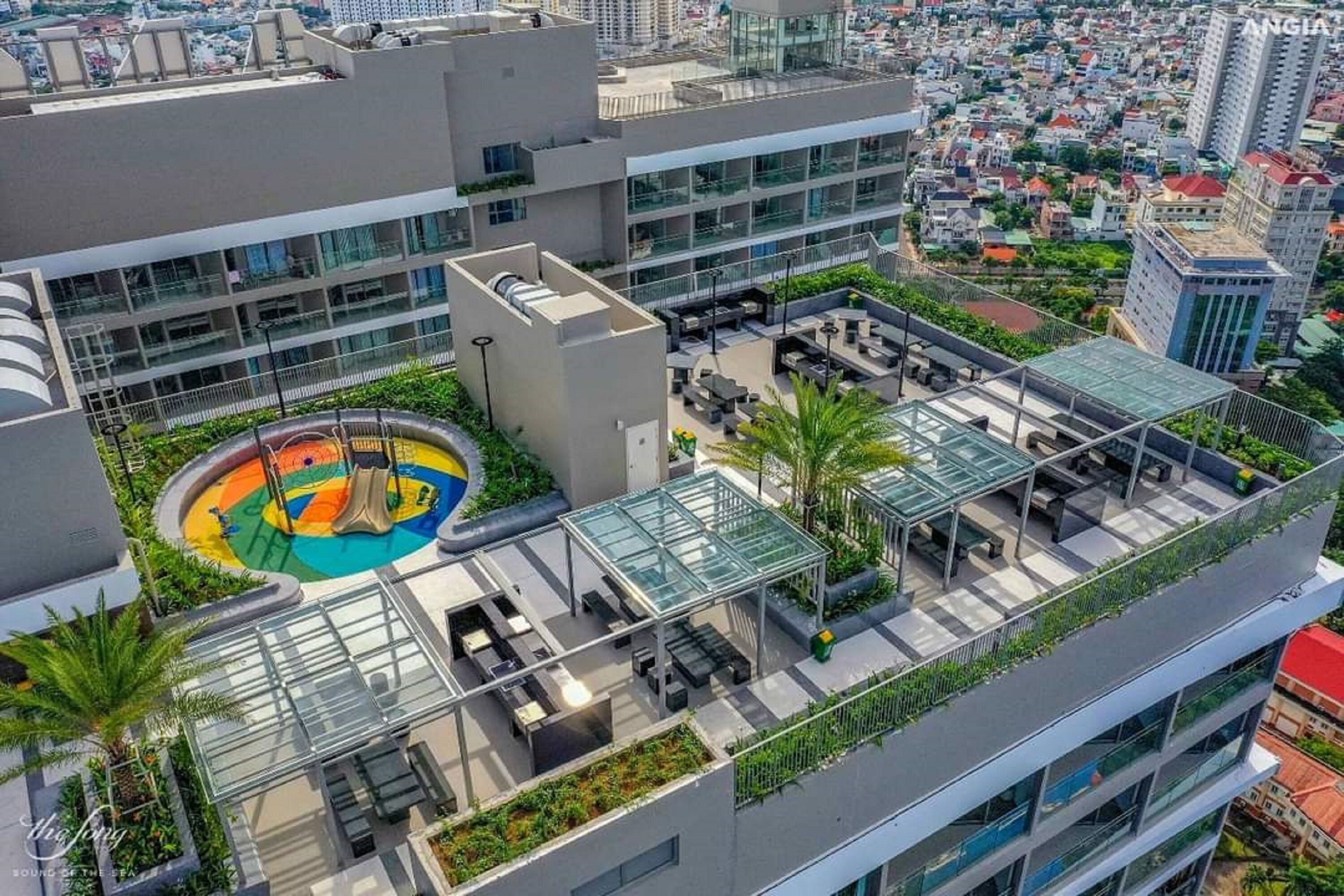 A rooftop terrace with outdoor seating, a circular play area, and a glass-enclosed lounge.