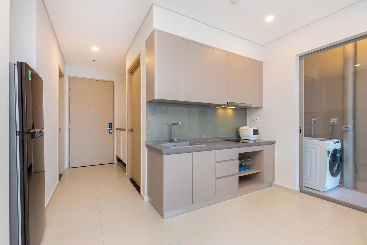 A modern kitchen with a built-in oven, a sink, and a washing machine.