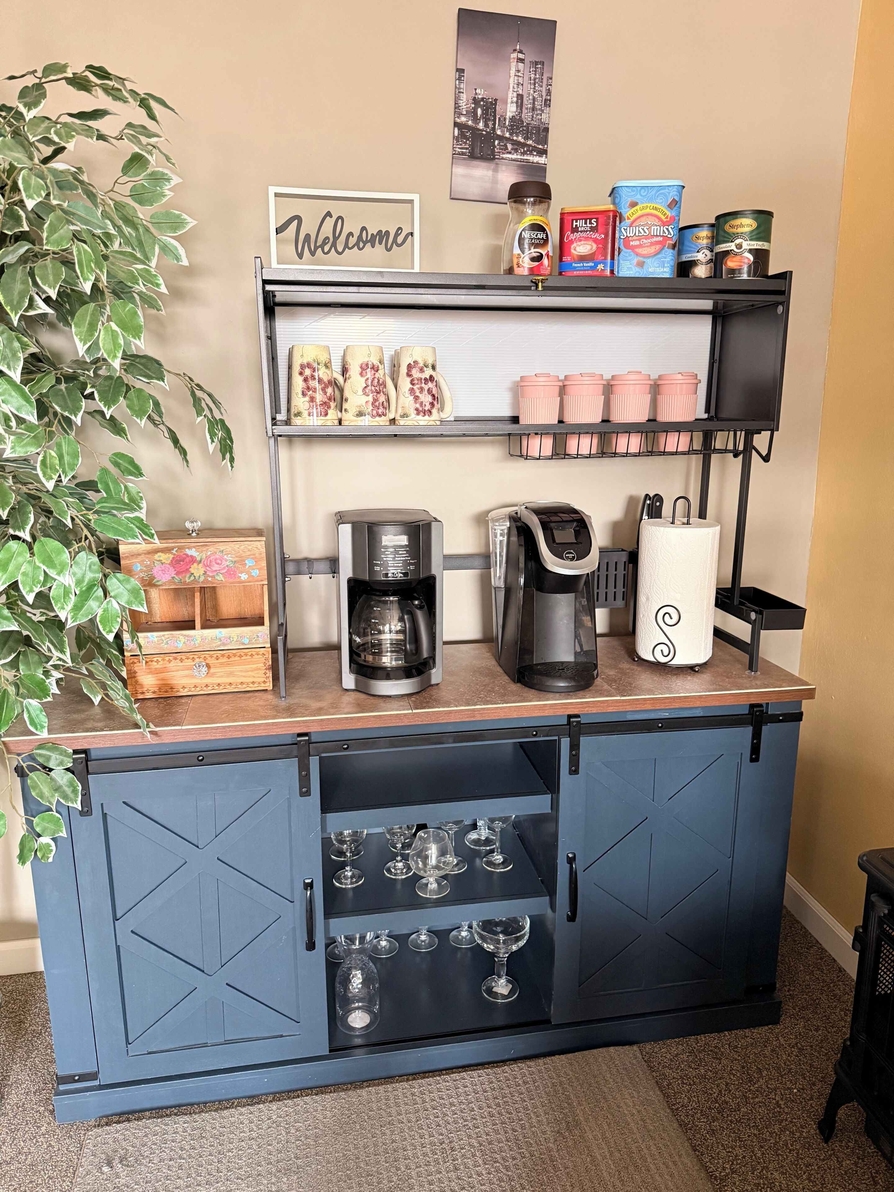 A coffee station with a coffee maker, a coffee grinder, and various coffee pods.