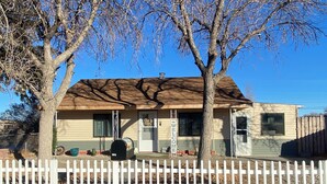 A single-story house with a front porch, a mailbox, and a 'WELCOME' sign.