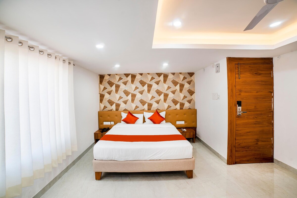 Una habitación de hotel con una cama, mesitas de noche, una puerta de madera y una pared con estampado.