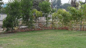 A grassy area with trees and a fence. - The Byke Business - Chandigarh House (Bhopal)