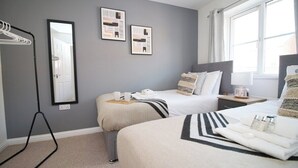 A hotel room with two beds, a large mirror, and artwork on the wall. - Gwent View by Tŷ SA (Newport)