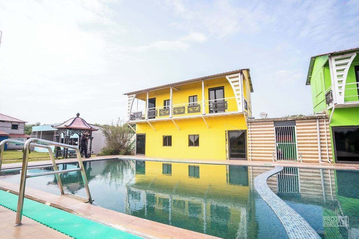 A swimming pool with a yellow building in the background.
