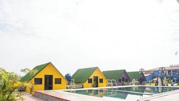 A pool area with colorful buildings, a clear sky, and a water feature.