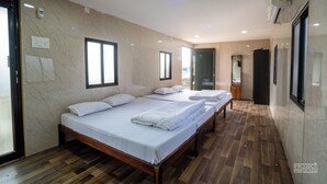 Une chambre d’hôtel avec un grand lit, un plancher en bois et un mur en marbre.