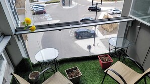 A balcony with two chairs, a small table, and potted plants. - Cozy Condo-Apartment/Suite in Brampton (Brampton)