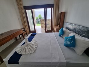 Una habitació d'hotel amb llit, escriptori i vista a l'exterior.
