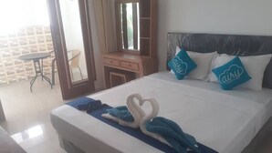 A hotel room with a bed, a desk, a chair, and a window. - Mulia Cottage Jimbaran (Jimbaran)