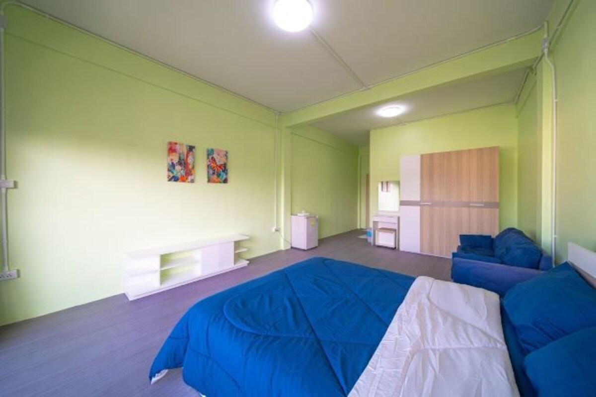 A room with a large bed, a desk, and a wardrobe.
