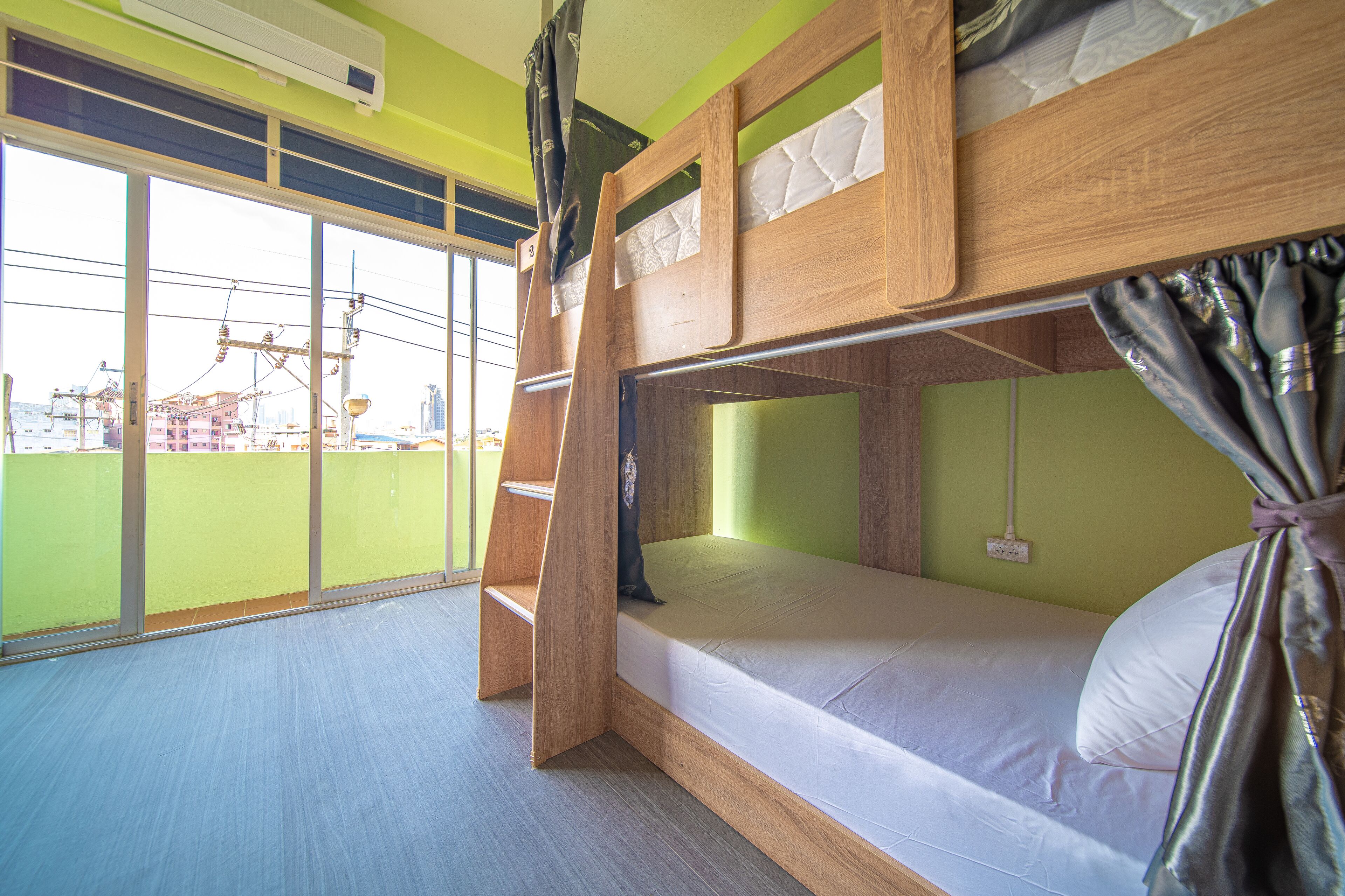 A bunk bed room with a window view of a cityscape.