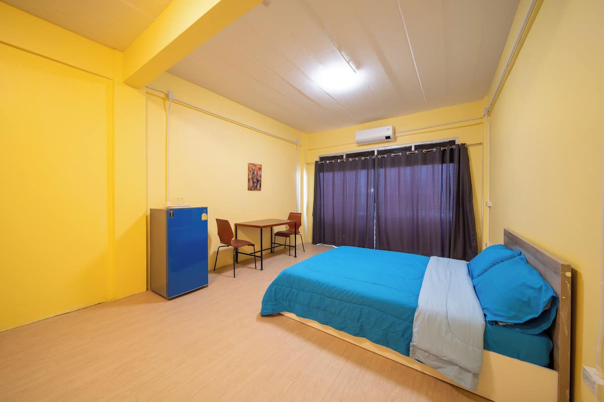 Una stanza con un letto, una scrivania e una sedia.