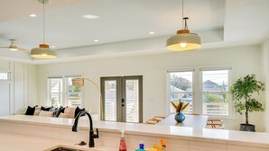 A modern kitchen with a large island, stainless steel sink, and pendant lighting. - Walk to Beach: PCB Retreat w/ Heated Pool! (Panama City Beach)