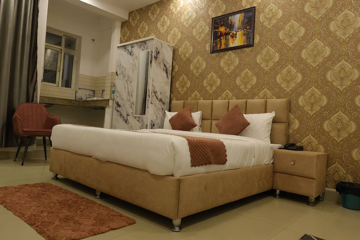 Une chambre à coucher comprenant un lit, une table de chevet, une chaise, une armoire et un bureau avec un miroir.