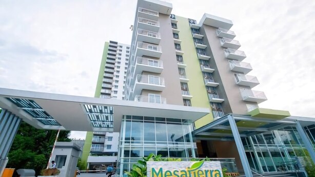 Un edificio moderno con un letrero que dice "Mesaterra Garden Residences".