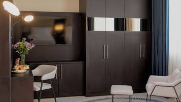 A modern living room with dark wood furniture, a flat-screen TV, and a seating area with a rug.