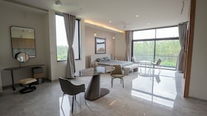 A modern bedroom with a bed, bedside tables, a desk, and chairs.