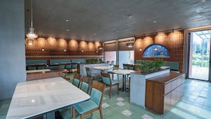 A restaurant interior with booths, tables, and a decorative wall.
