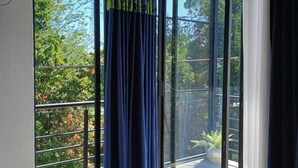 Un balcón con vista a la vegetación y una barandilla de metal.