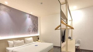 Ein modernes Schlafzimmer mit einem großen Bett, einem Nachttisch, einem Schreibtisch und einem Stuhl.
