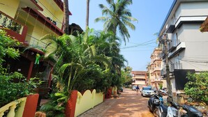 A narrow street lined with residential buildings, some with balconies and plants. - Arooba Residency Calangute (Calangute)