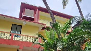 A two-story building with a balcony and a staircase leading to the upper floor.