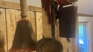 Un intérieur rustique avec des murs en bois et une cloche suspendue au plafond.