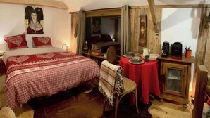 Une chambre confortable avec un grand lit, une petite table avec de la vaisselle et un meuble en bois.