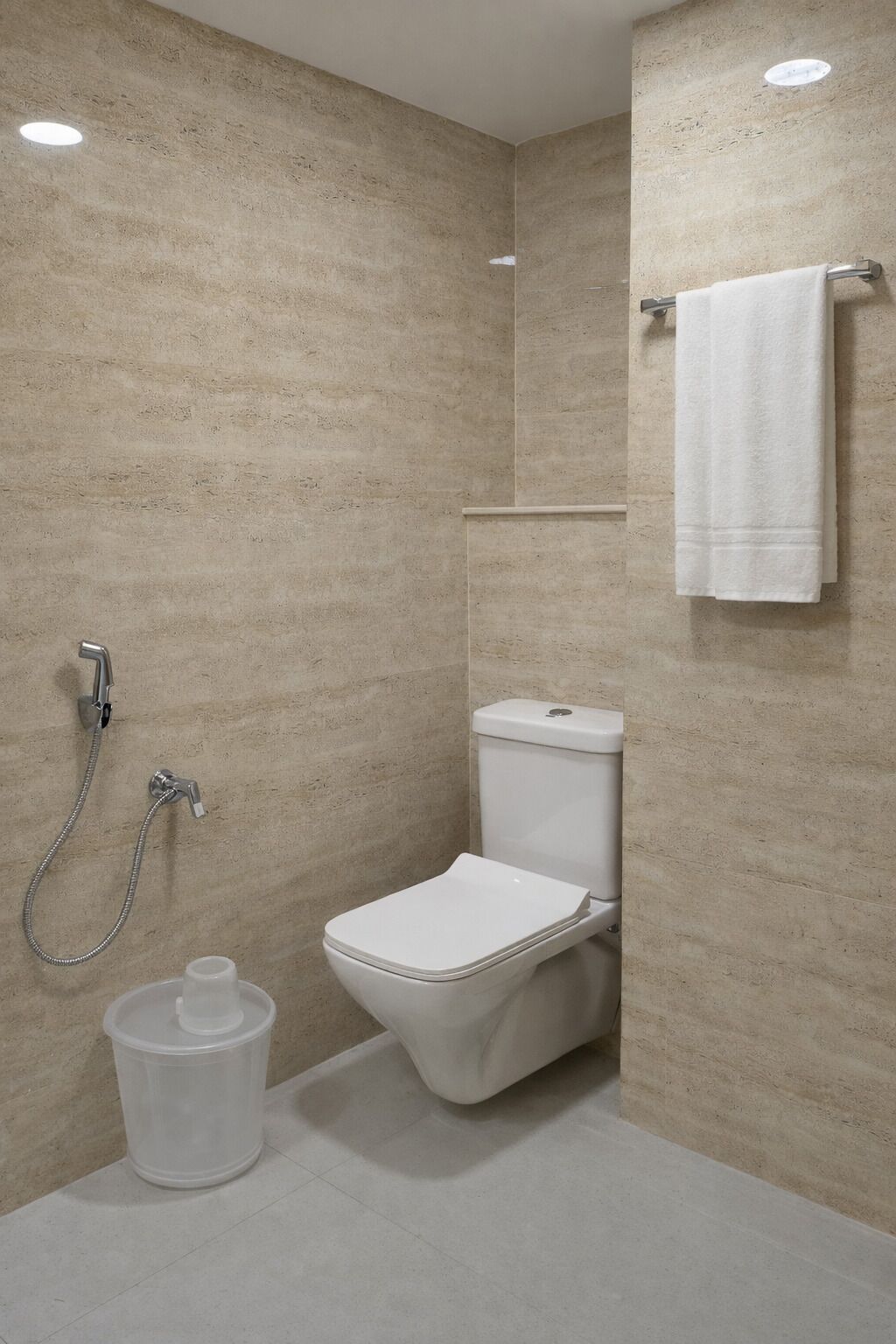 A modern bathroom with a toilet, shower, and a towel rack.
