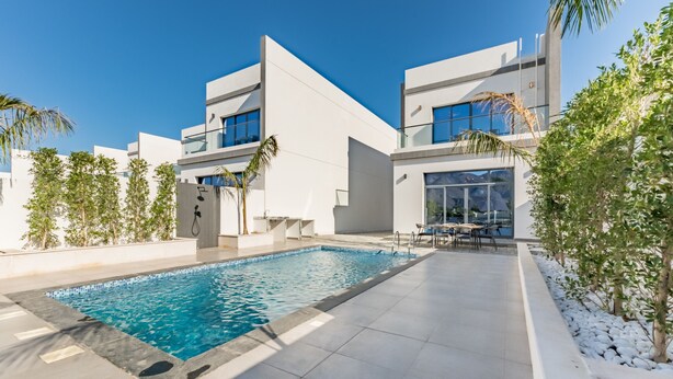 A modern pool area with a rectangular pool, adjacent to a building with large windows and a flat roof. - Escape to a Modern 3BR Villa w/ a Private Pool & Mountain Views, Al Dana Island (Fujairah)