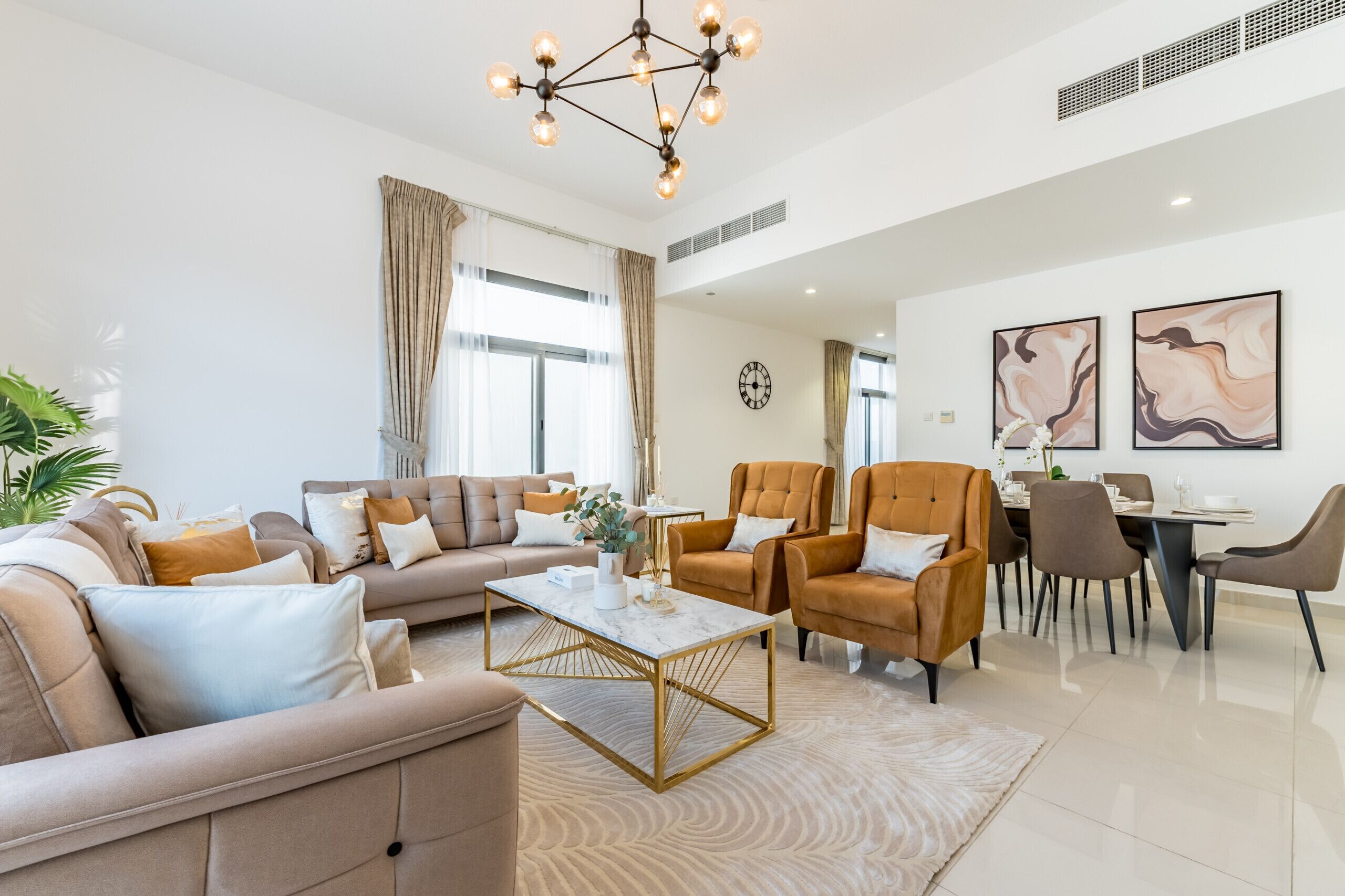 A modern living room with a sofa set, a coffee table, and a dining area with chairs and a table.