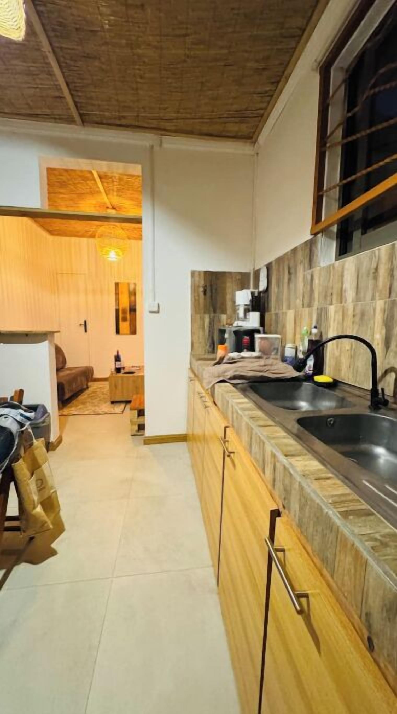 Una cocina moderna con armarios de madera, un lavamanos integrado y una ventana.