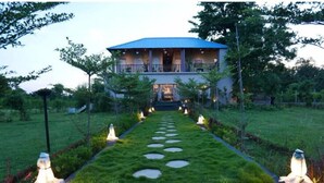 A house with a blue roof, a front porch, and a pathway leading to the entrance. - Jewel Stay (Manpur)