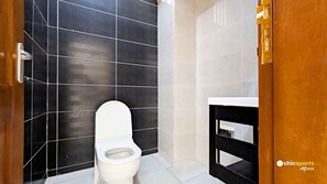 Bathroom features a minimalist design with a bold tile contrast and a simple layout.