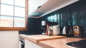 A kitchen with a wooden countertop, a coffee maker, a kettle, and a box of vanilla extract. - Le Colimaçon - Half-timbered house (Tours)