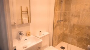 Un bagno con lavandino, WC e zona doccia.