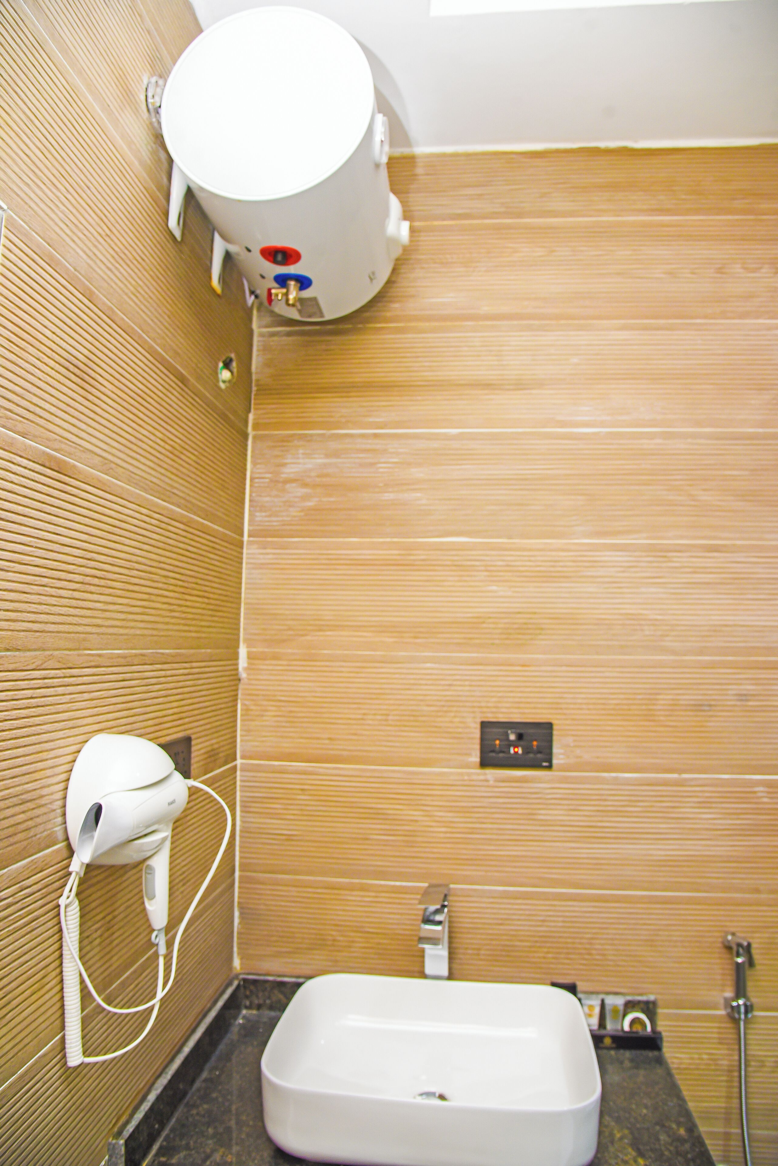 A bathroom with a white sink, a hairdryer, a towel rack, and a shower.