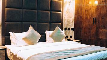 Una habitación de hotel moderna con una cama grande, un armario de madera y una cabecera de mármol.