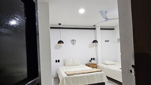 Un dormitorio con cama, mesitas de noche y ventilador de techo.