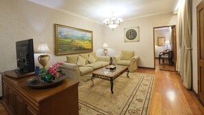 Una sala de estar con sofá, mesa de centro, televisión y objetos decorativos.