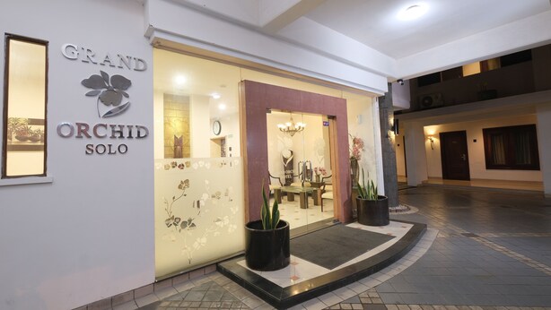 Entrada de hotel con un cartel que dice "GRAND ORCHID SOLO".